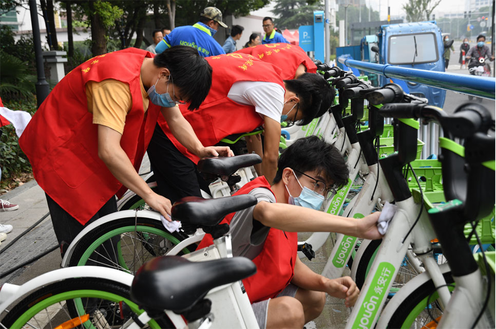 世界無車日，志愿者走上街頭擦亮共享助力車